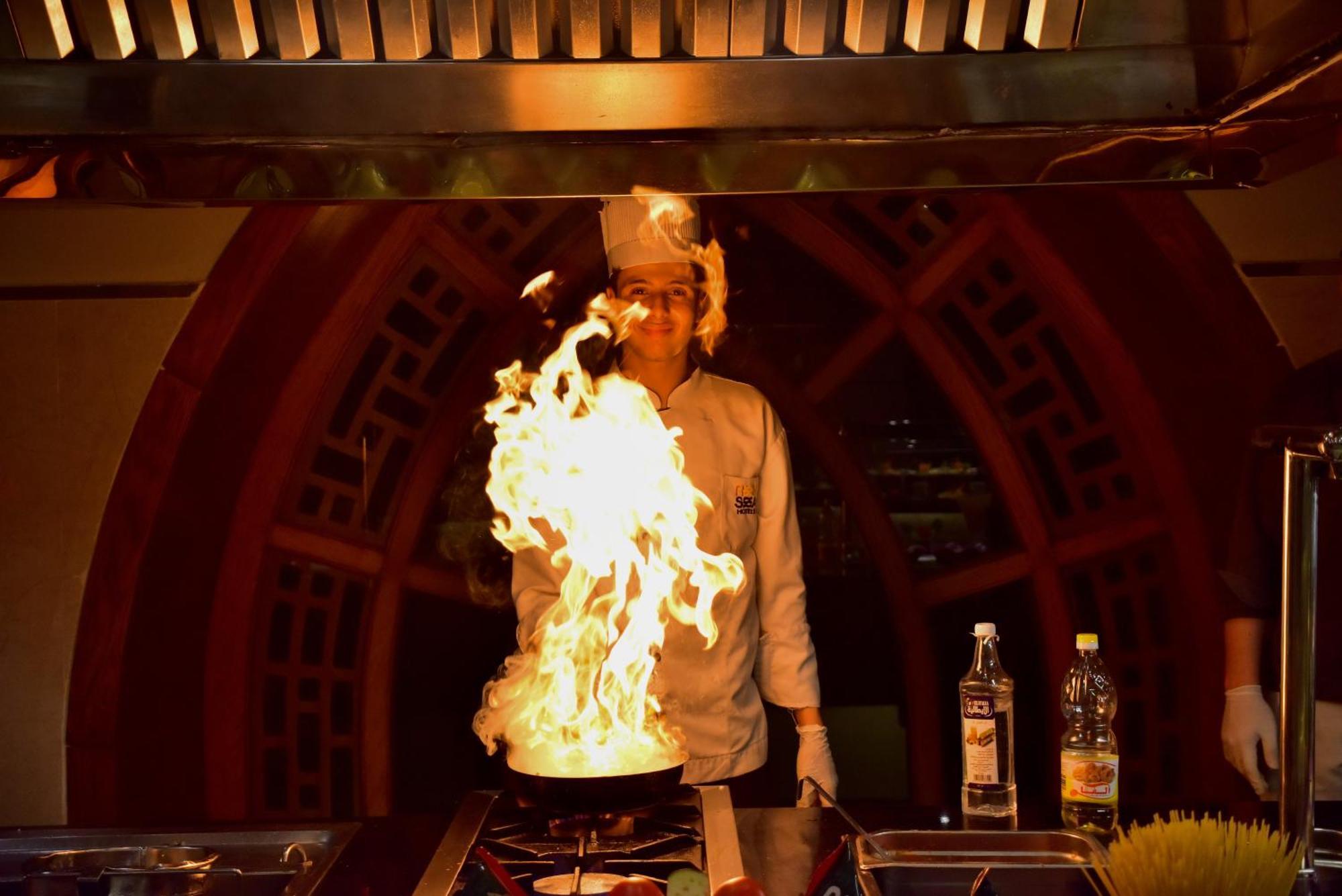The Grand Hotel Sharm El Sheikh 外观 照片 A chef cooking with a flaming wok
